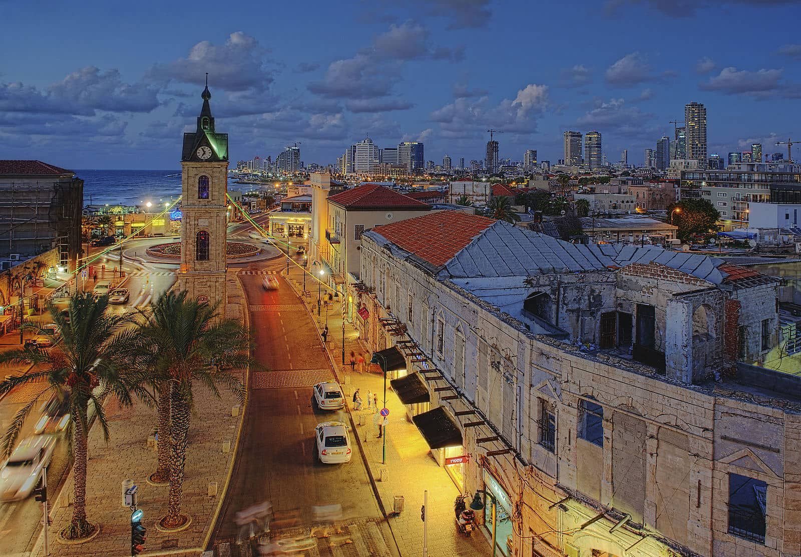 Old Jaffa clock tower at dusk, with Tel Aviv skyline beyond